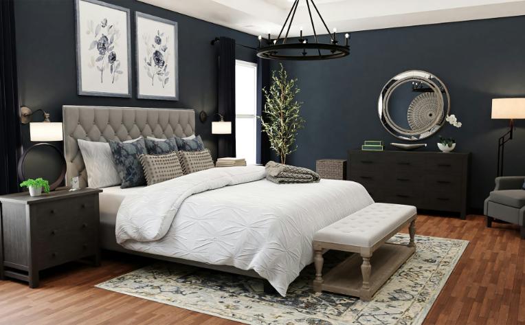 cozy bedroom with wood flooring and area rug with blue walls and grey and white bed with black furniture.